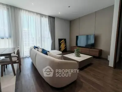 Modern living room with elegant furniture and large windows offering city views.