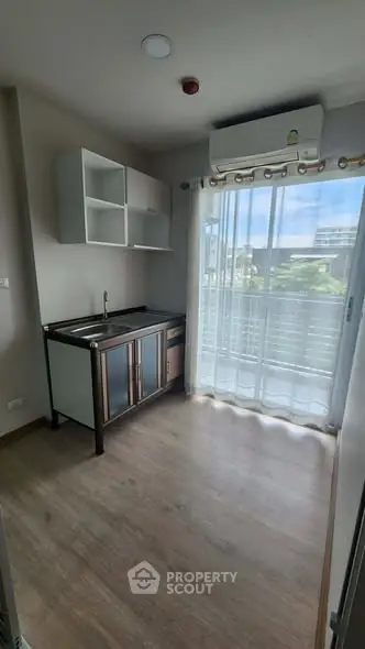 Modern kitchen with sleek cabinetry and large window offering natural light and scenic view.