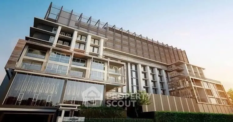 Modern architectural building with glass facade and lush greenery.