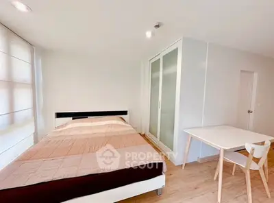 Bright and modern bedroom with minimalist decor and ample natural light.