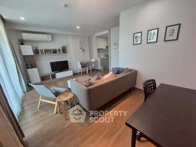 Modern living room with stylish furniture and open layout, featuring a cozy sofa and dining area.
