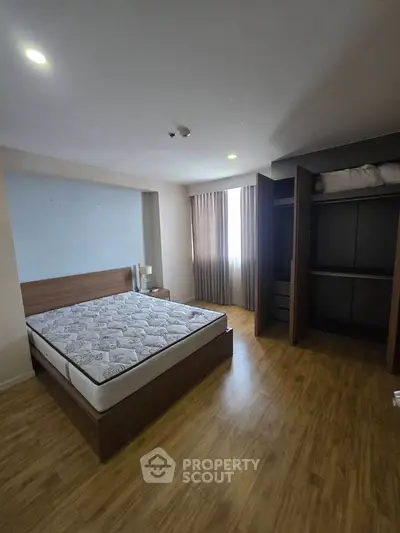 Spacious bedroom with wooden flooring and built-in wardrobe
