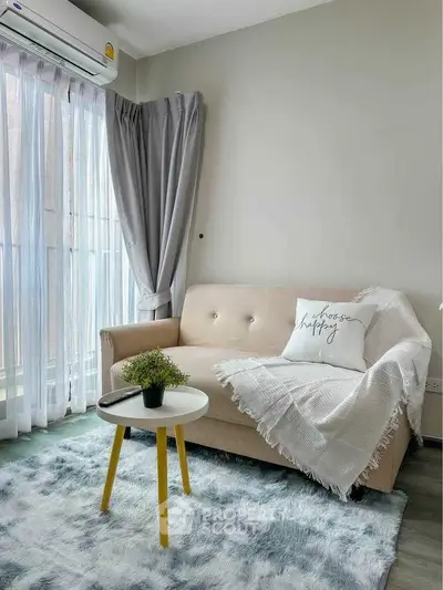 Cozy living room with stylish sofa, chic rug, and natural light from large window.