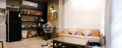 Stylish living room with modern decor, featuring a cozy sofa, elegant coffee table, and open shelving with decorative items.