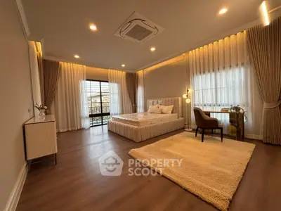 Spacious bedroom with elegant decor and large windows for natural light.