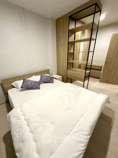 Modern bedroom with stylish shelving and cozy bedding in a contemporary apartment.