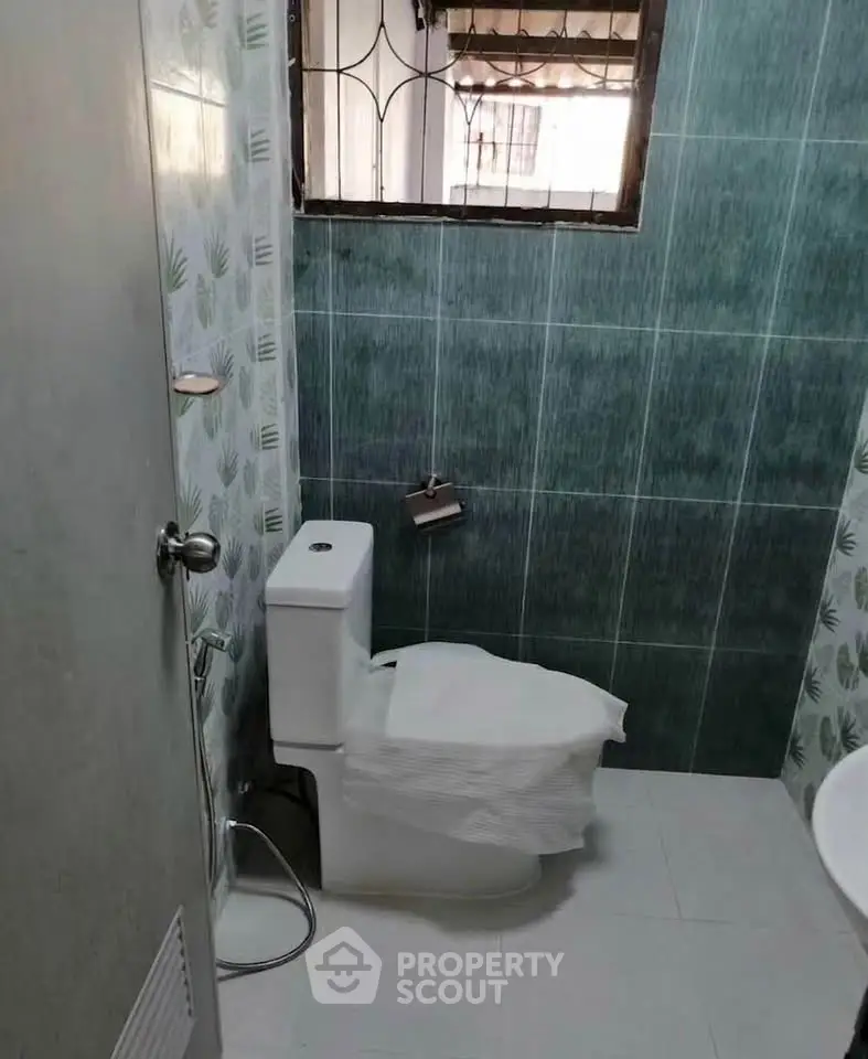 Compact bathroom with modern toilet and tiled walls, ideal for small spaces.