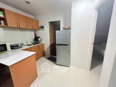 Modern kitchen with sleek cabinets and stainless steel fridge in cozy apartment