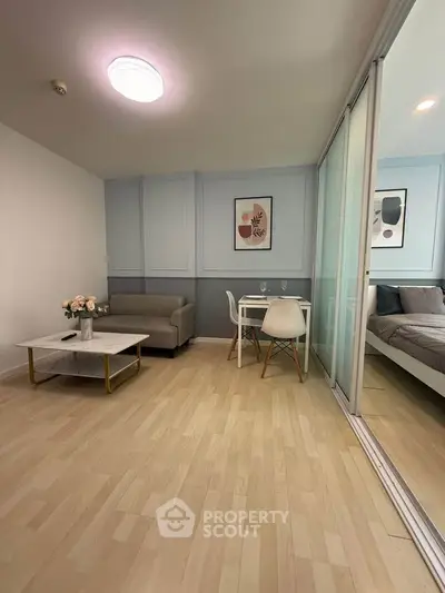 Modern living room with stylish decor and cozy dining area in open layout apartment.