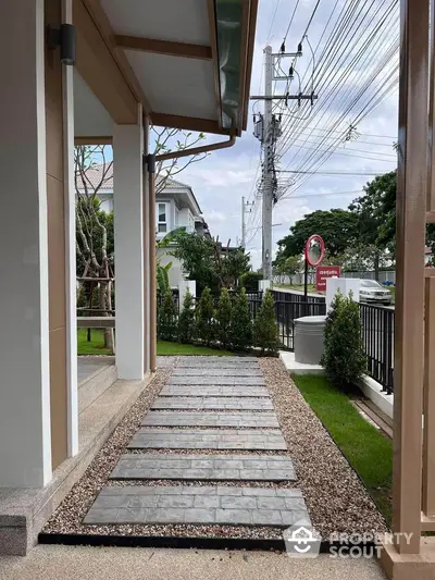 Modern house exterior with landscaped garden and stone pathway