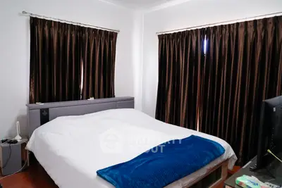 Cozy bedroom with dark curtains and modern decor, perfect for restful nights.