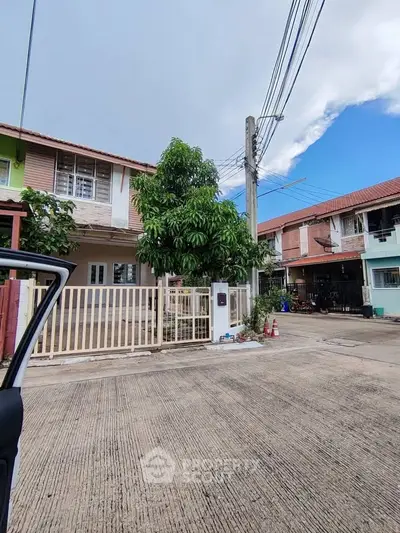 Charming residential neighborhood with two-story houses and lush greenery.