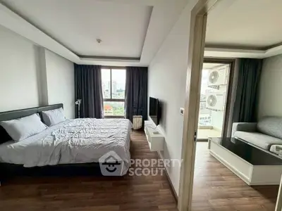 Modern bedroom with city view and cozy living area in a stylish apartment.