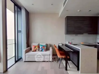 Modern living room with open kitchen and balcony access, featuring sleek design and cozy seating.