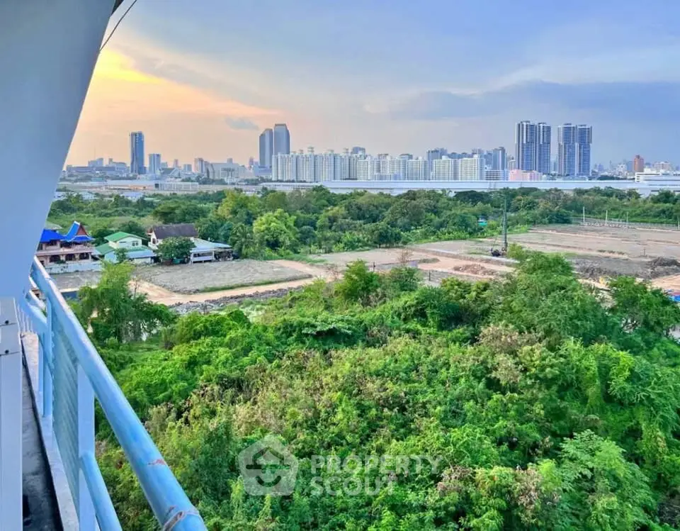 Stunning cityscape view from a high-rise balcony overlooking lush greenery and urban skyline.