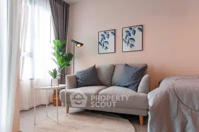 Cozy living room with modern decor, featuring a plush sofa, stylish artwork, and abundant natural light.