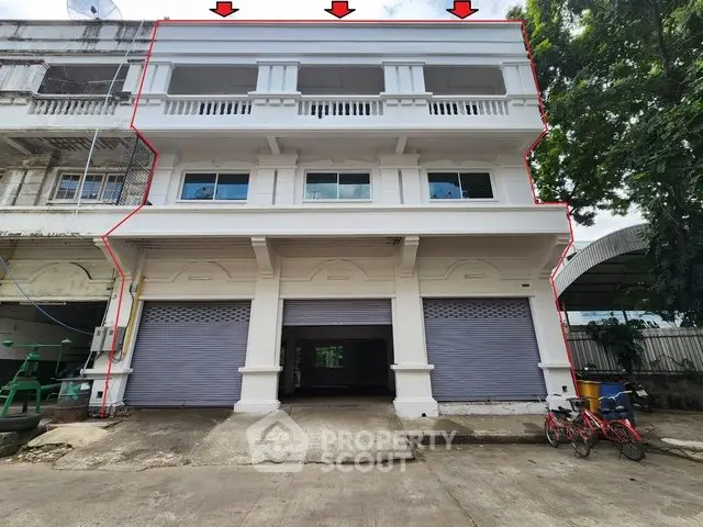Spacious commercial building with three floors and large garage doors, ideal for business use.