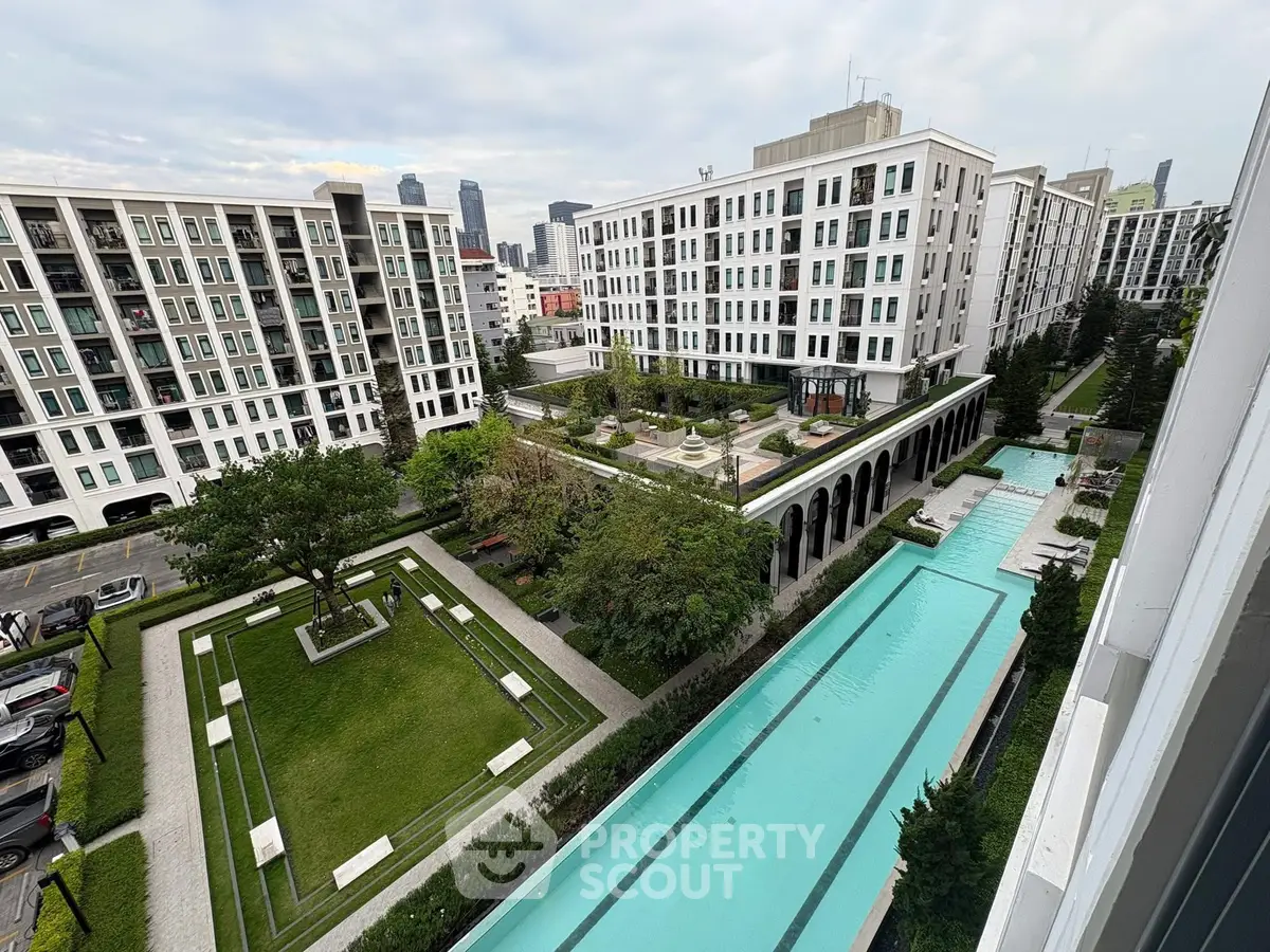Luxurious apartment complex with stunning pool and garden view in urban setting.