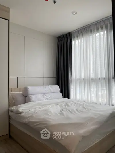 Modern bedroom with large window and stylish decor in urban apartment