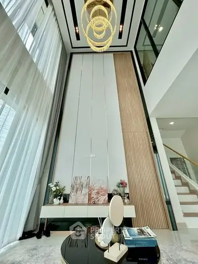 Luxurious modern living room with high ceilings and elegant chandelier