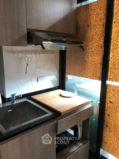 Modern compact kitchen with sleek cabinetry and built-in appliances