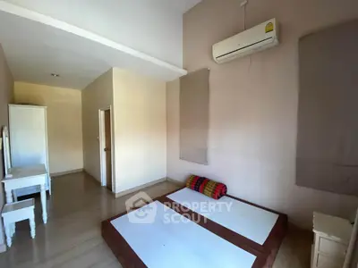 Minimalist bedroom with air conditioning and simple furnishings