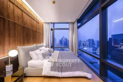 Luxurious bedroom with stunning city view and modern decor in high-rise apartment.