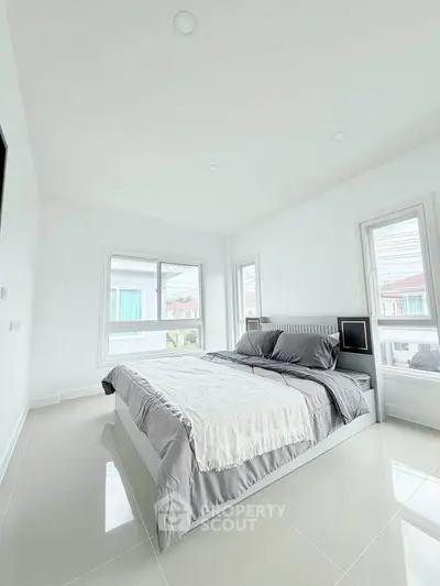 Bright and spacious bedroom with modern decor and large windows in a contemporary home.
