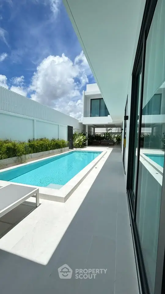 Luxurious modern villa with private pool and sleek architecture under a bright blue sky.