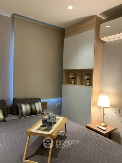 Cozy bedroom with modern decor and ambient lighting, featuring a stylish bed and elegant side table.