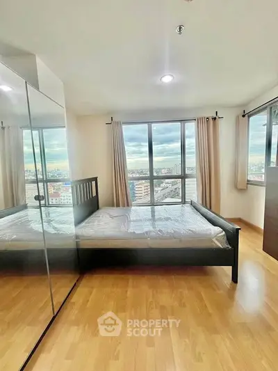 Spacious bedroom with city view and mirrored wardrobe