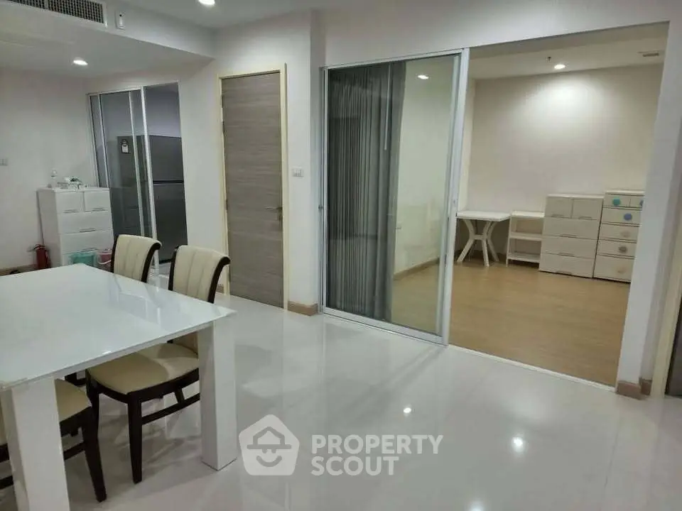 Spacious modern dining area with sliding glass doors leading to a versatile room, ideal for family living.