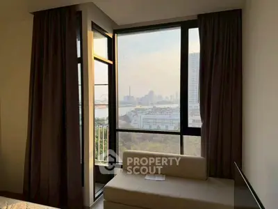 Modern apartment with floor-to-ceiling windows offering stunning city views and cozy seating area.