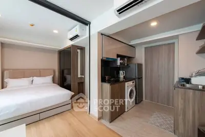 Modern studio apartment with integrated kitchen and cozy bedroom.