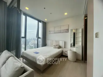 Modern bedroom with city view, featuring a cozy bed and stylish decor.
