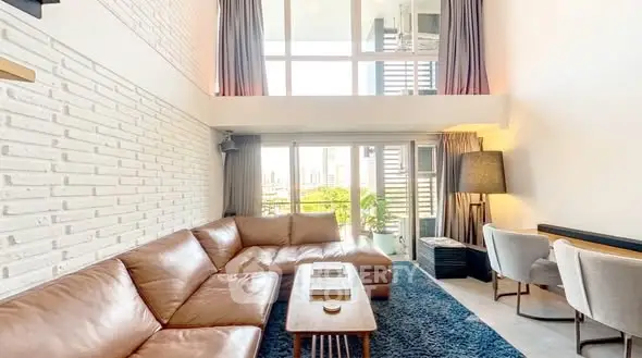 Spacious modern living room with large windows and stylish decor in urban apartment.