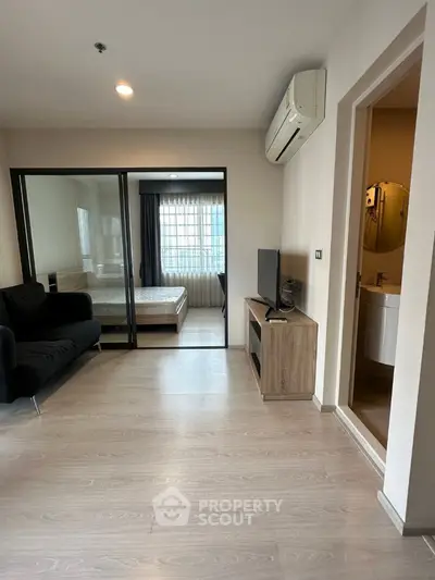 Modern apartment interior with living room, bedroom, and bathroom view, featuring sleek design and natural light.