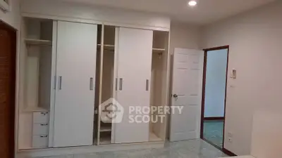 Spacious bedroom with built-in wardrobe and open door to hallway