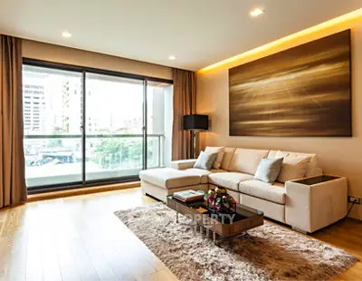 Luxurious living room with large windows and modern decor in a high-rise apartment.