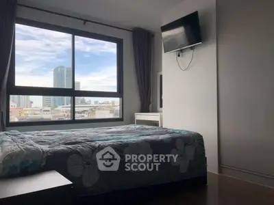 Modern bedroom with large window and city view, featuring a wall-mounted TV and stylish decor.