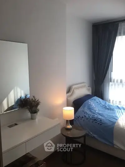 Cozy bedroom with elegant decor and natural light, featuring a stylish bed and bedside lamp.