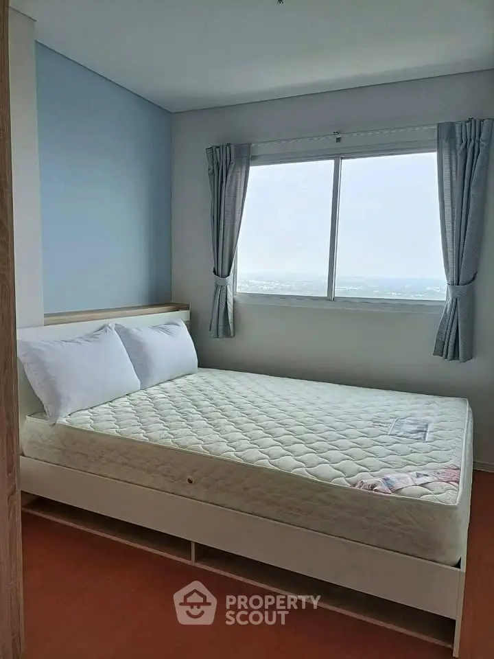 Bright bedroom with large window and minimalist decor, featuring a comfortable bed and serene ambiance.