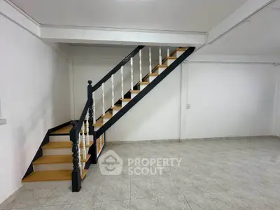 Spacious interior with modern staircase and tiled flooring, perfect for customization.