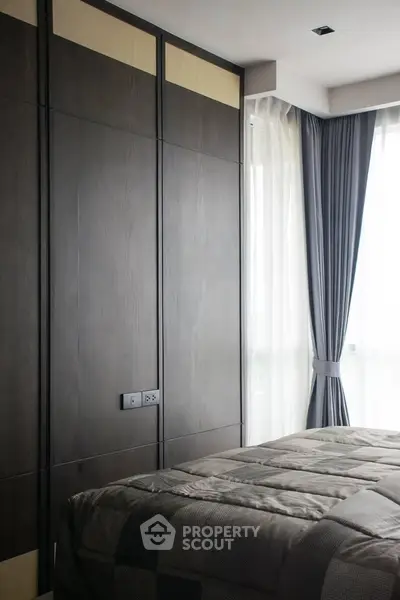 Modern bedroom with stylish dark wood paneling and large window with elegant curtains.