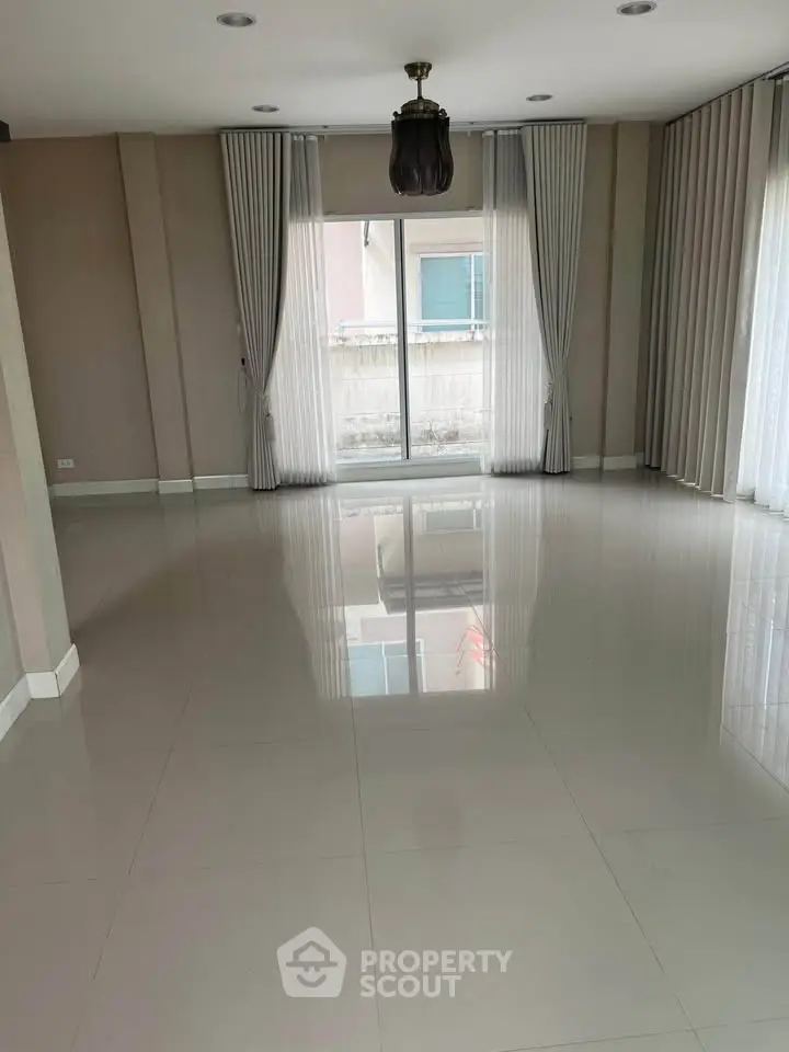 Spacious empty living room with large windows and elegant curtains, perfect for customization.