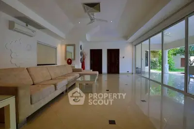 Spacious living room with modern decor and large windows overlooking garden