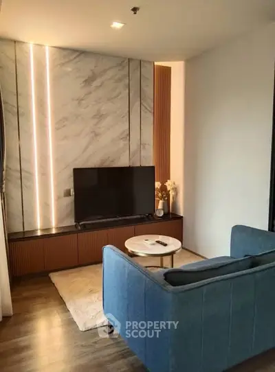 Modern living room with stylish marble accent wall and cozy seating area.