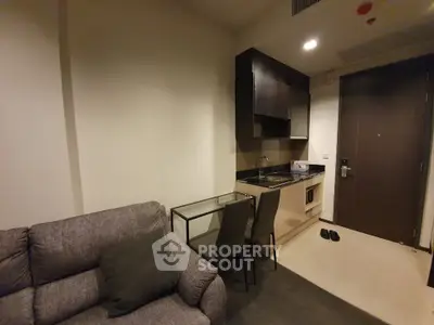 Cozy studio apartment with compact kitchen and comfortable seating area, perfect for urban living.