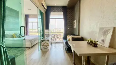 Modern studio apartment with glass partition, cozy living area, and balcony view.