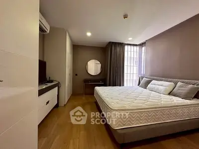 Spacious modern bedroom with wooden flooring and stylish decor